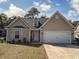 Charming single-story home featuring a two-car garage and a well-maintained front yard on a sunny day at 13 Daniel Morrall Ln., Georgetown, SC 29440