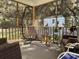 Inviting screened-in sunroom with hanging chair, perfect for relaxation and enjoying the outdoors at 13 Daniel Morrall Ln., Georgetown, SC 29440