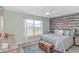 Cozy bedroom featuring a decorative accent wall, comfortable queen bed, and serene window view at 135 Butkus Dr. # 5, Myrtle Beach, SC 29588