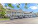A tan two-story condo building with white railing and staircase is surrounded by parked cars at 135 Butkus Dr. # 5, Myrtle Beach, SC 29588