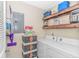 Laundry room features a washer, dryer, storage shelves and containers, and a broom and dustpan at 135 Butkus Dr. # 5, Myrtle Beach, SC 29588