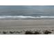 A serene view of the sandy beach meeting the ocean's edge, with gentle waves rolling in at 1501 S Ocean Blvd. # 935, Myrtle Beach, SC 29577