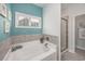 The bathroom has a soaking tub, window, and tiled shower with glass doors at 172 Board Landing Circle, Conway, SC 29526