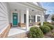 Inviting front porch with brick accents, white columns, and a charming teal door at 172 Board Landing Circle, Conway, SC 29526