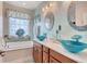 Beautiful bathroom with double vanities, unique blue glass sinks, and a relaxing soaking tub at 1878 Heritage Loop, Myrtle Beach, SC 29577