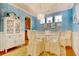 Dining room with a decorative chandelier, seating for four, blue accent wall, and white built in cabinet at 1878 Heritage Loop, Myrtle Beach, SC 29577