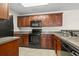 Well-lit kitchen featuring dark cabinetry, black appliances and tile flooring at 200 Vendura Ct. # B, Murrells Inlet, SC 29576