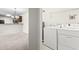 Functional laundry area with washer, dryer, overhead rack, and adjacent dining area at 200 Vendura Ct. # B, Murrells Inlet, SC 29576