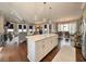 Open concept kitchen with center island, hardwood floors, and modern pendant lighting at 202 Spreading Oak Dr., Pawleys Island, SC 29585