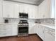 Modern kitchen with white cabinets, stainless steel appliances, and stylish backsplash at 202 Spreading Oak Dr., Pawleys Island, SC 29585