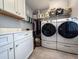 Modern laundry room with white cabinets, countertops, a clothes rack, storage, and a stacked washer and dryer at 202 Spreading Oak Dr., Pawleys Island, SC 29585