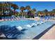 Sparkling pool with in-water seating, deck chairs, and lush tropical landscaping at 210 Double Eagle Dr. # G1, Myrtle Beach, SC 29575