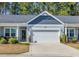 Charming home featuring a two-car garage, tidy landscaping and a quaint covered porch at 309 Lake Mist Ct. # 309, Longs, SC 29568