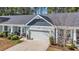 Aerial view of a charming single story home featuring a two-car garage, tidy landscaping and a quaint covered porch at 309 Lake Mist Ct. # 309, Longs, SC 29568