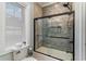 Modern bathroom featuring a shower-tub with glass door and gray tile, paired with a convenient toilet and accessories at 3100 Lahinch Dr., Myrtle Beach, SC 29579