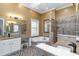 Luxurious bathroom with a soaking tub, granite counters, mosaic tile accents, and a separate vanity area at 3100 Lahinch Dr., Myrtle Beach, SC 29579