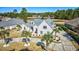 Beautifully landscaped front yard with palm trees leading to a distinguished white brick home with a gray roof at 3100 Lahinch Dr., Myrtle Beach, SC 29579