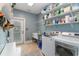 Functional laundry room with a utility sink, storage shelves, and modern washer and dryer units at 3100 Lahinch Dr., Myrtle Beach, SC 29579