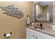 Charming powder room featuring a granite countertop, decorative bowl sink, and unique fish-themed wall decor at 3100 Lahinch Dr., Myrtle Beach, SC 29579