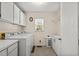 A laundry room has tile floors, storage cabinets, a window, and modern appliances at 321 Jay St., Murrells Inlet, SC 29576