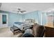 A comfortable main bedroom featuring a ceiling fan and relaxing chair is bathed in the soft blue light of afternoon at 321 Jay St., Murrells Inlet, SC 29576