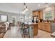 Open kitchen with wood cabinets, island seating, and adjacent living area with abundant natural light at 3600 White Wing Circle, Myrtle Beach, SC 29579