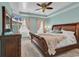 Cozy main bedroom featuring a tray ceiling, ceiling fan, and a large bed with a wooden frame at 3600 White Wing Circle, Myrtle Beach, SC 29579