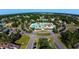 Aerial view of a community pool and clubhouse surrounded by lush green trees and homes at 410 Starlit Way, Myrtle Beach, SC 29579