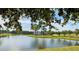 Picturesque view of a pond reflecting a clubhouse, framed by verdant trees and landscaping at 410 Starlit Way, Myrtle Beach, SC 29579