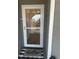 View of front door with storm door and welcome mat on gray porch at 4519 N Plantation Harbour Dr. # X - 19, Little River, SC 29566