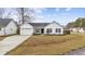 Charming one-story white home with a well-manicured lawn, attached garage and inviting curb appeal at 453 Saint Charles Circle, Myrtle Beach, SC 29588