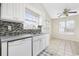 Eat in kitchen with window, tile backsplash, stainless sink, and modern white appliances at 453 Saint Charles Circle, Myrtle Beach, SC 29588