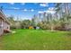 Spacious backyard with green grass, mature trees, and a shed in the distance at 4810 Circle Dr., Loris, SC 29569