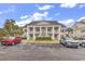 Inviting condo building featuring stately columns, well-maintained landscaping, and convenient parking at 4936 Crab Pond Ct. # 201, Myrtle Beach, SC 29579