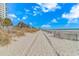 Sandy beach leading up to a condominium building on a bright, sunny day at 504 N Ocean Blvd. # 310, Myrtle Beach, SC 29577