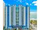 A full exterior view of the multi-story condo, with a view of the ocean on a bright day at 504 N Ocean Blvd. # 310, Myrtle Beach, SC 29577