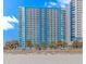 Exterior shot of a beachfront condo high-rise with a striking blue and white facade and palm trees at 504 N Ocean Blvd. # 310, Myrtle Beach, SC 29577