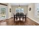 Bright dining room with hardwood floors, natural light, and seating for six, ideal for gatherings at 556 Timber Creek Dr., Loris, SC 29569