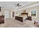 Spacious main bedroom featuring tray ceilings, plush carpeting, and an ensuite bathroom at 556 Timber Creek Dr., Loris, SC 29569