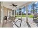 Relaxing screened porch featuring a ceiling fan, dining set, and views of the manicured backyard at 556 Timber Creek Dr., Loris, SC 29569