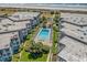 Aerial view of the condo complex pool near the beach with well-manicured lawns, palm trees, and beach access at 5601 N Ocean Blvd. # E-111, Myrtle Beach, SC 29577