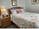 Cozy bedroom with a queen-sized bed, floral bedding, and wood-look laminate flooring at 5601 N Ocean Blvd. # E-111, Myrtle Beach, SC 29577