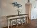 A console table with a gray top and white painted wood sits in a dining area at 5601 N Ocean Blvd. # E-111, Myrtle Beach, SC 29577