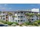 Charming condo building with multiple balconies, lush landscaping, and palm trees near the parking area at 5601 N Ocean Blvd. # E-111, Myrtle Beach, SC 29577