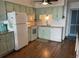 The kitchen has hardwood floors, white appliances, and seafoam green cabinets at 5601 N Ocean Blvd. # E-111, Myrtle Beach, SC 29577