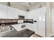 White kitchen features granite countertops, tile backsplash, tile floors, and modern appliances at 601 Hillside Dr. N # 3031, North Myrtle Beach, SC 29582