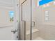 Bathroom shower with glass door, built-in bench, and tiled walls under a window at 619 Castle Ct., Myrtle Beach, SC 29579