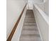 Carpeted stairs with wood handrail and white trim that leads to the upper levels of the home at 619 Castle Ct., Myrtle Beach, SC 29579
