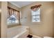 Bathroom featuring a large bathtub under windows and neutral wall color at 645 Twinflower St., Little River, SC 29566