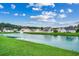 Picturesque lake view from the backyard featuring green lawn, with houses in the background at 645 Twinflower St., Little River, SC 29566